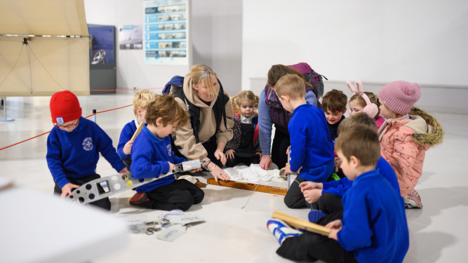 Children in a group looking at a model