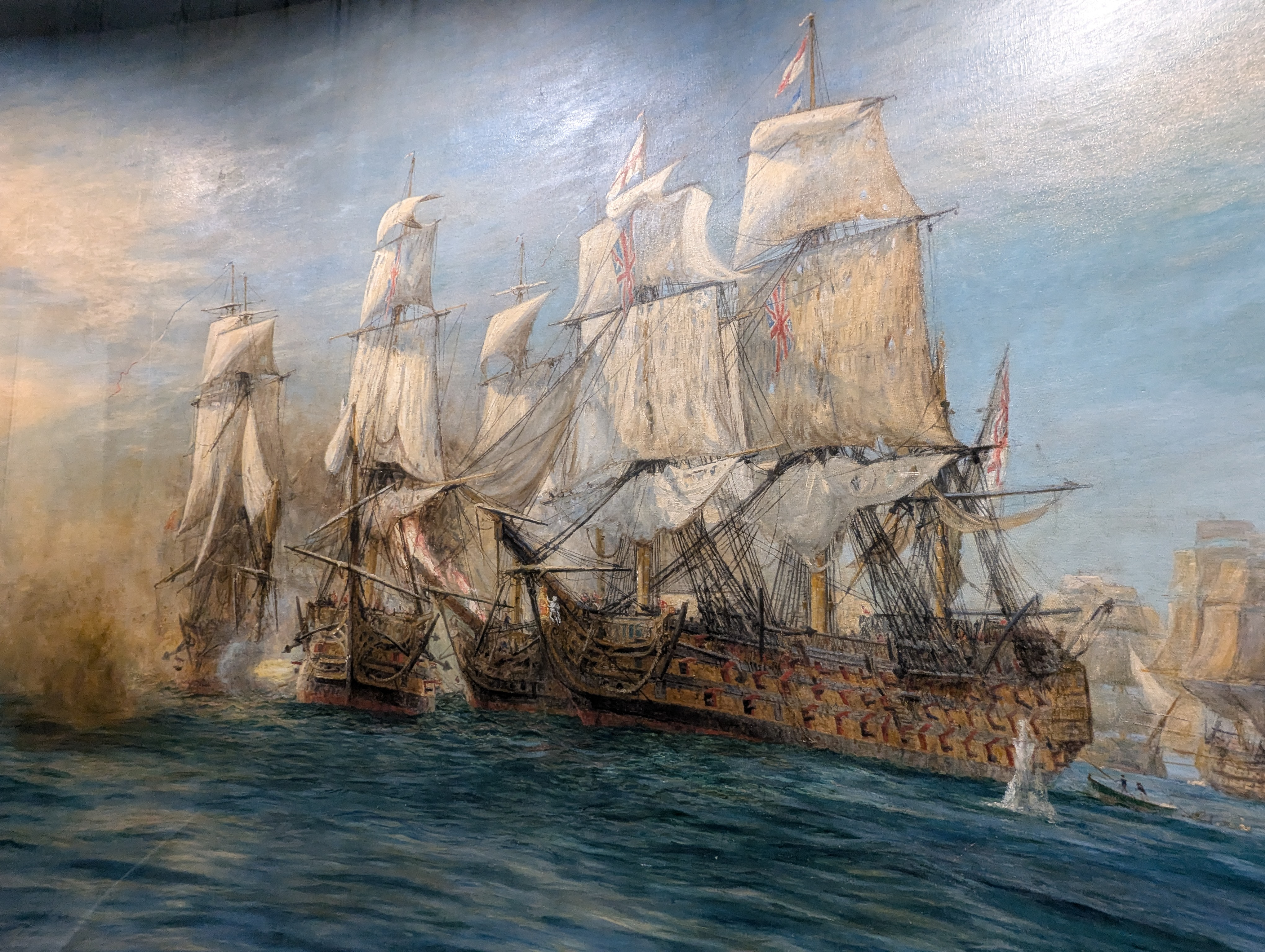 A close-up of a painting showcasing multiple Georgian-era ships locked in combat