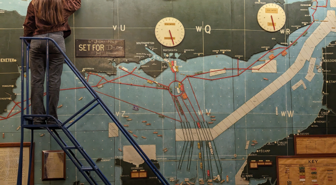 A conservator works at height conserving the D-Day map