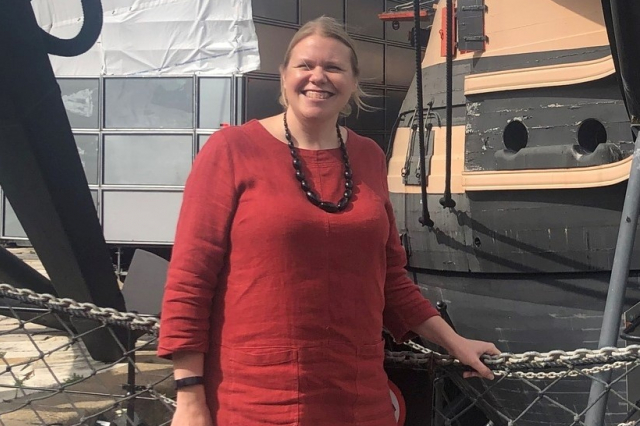 Woman in red top in front of HMS Victory