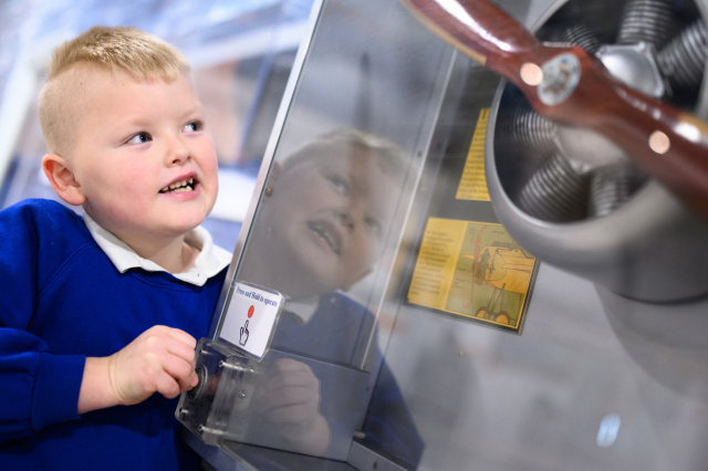 School child looking at propeller