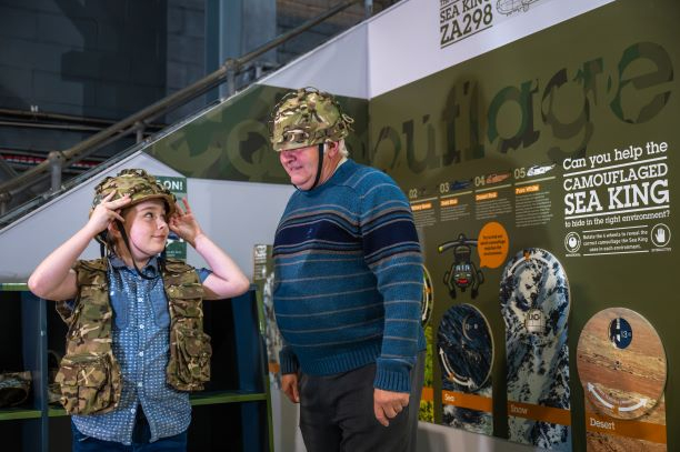 A grandfather and grandson try on replica khaki helmets and flak jackets at the Fleet Air Arm Museum