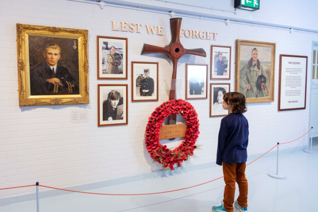 Child standing in front of memorial wall