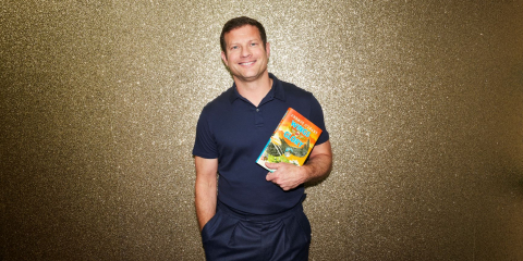 Dermot O'Leary holding a copy of his book 'Wings of Glory'