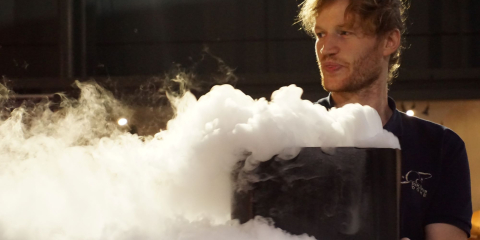 Scientist holding cauldron with smoke