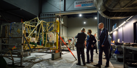 Three figures look on at the ongoing work to rebuild a Fairey Barracuda