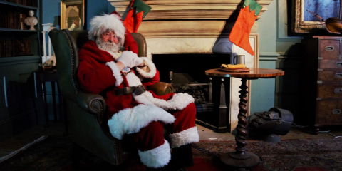 Santa Claus relaxing in a recreation of a Georgian study, complete with stockings above the fireplace. The study is part of a recreated Georgian quayside at the National Museum of the Royal Navy Hartlepool